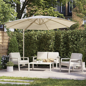 Outdoor patio set with cream umbrella, chairs, and table in a garden setting.